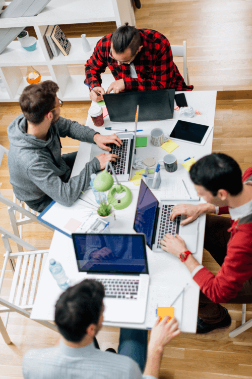 Men on their laptops at table